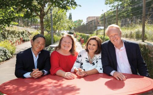 Four individuals stand together, smiling, as they collaborate in the fight against cervical cancer.